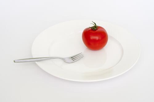 Красный помидор на белой тарелке
