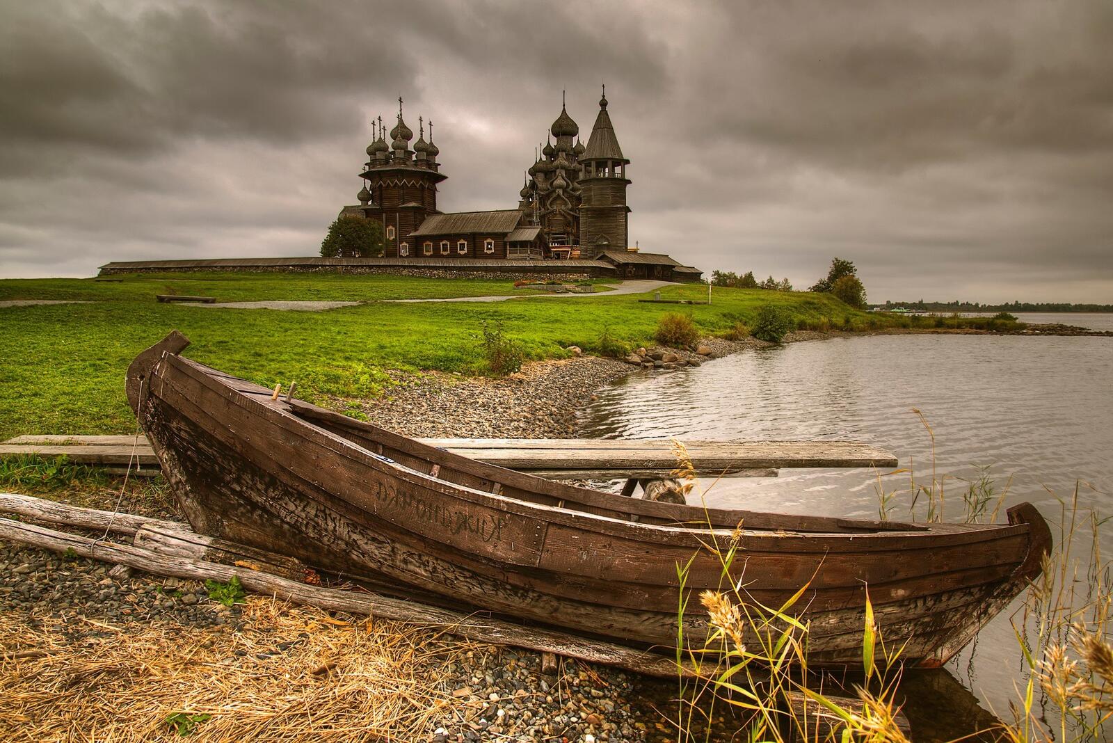 Бесплатное фото Деревянная лодка у деревянной церкви