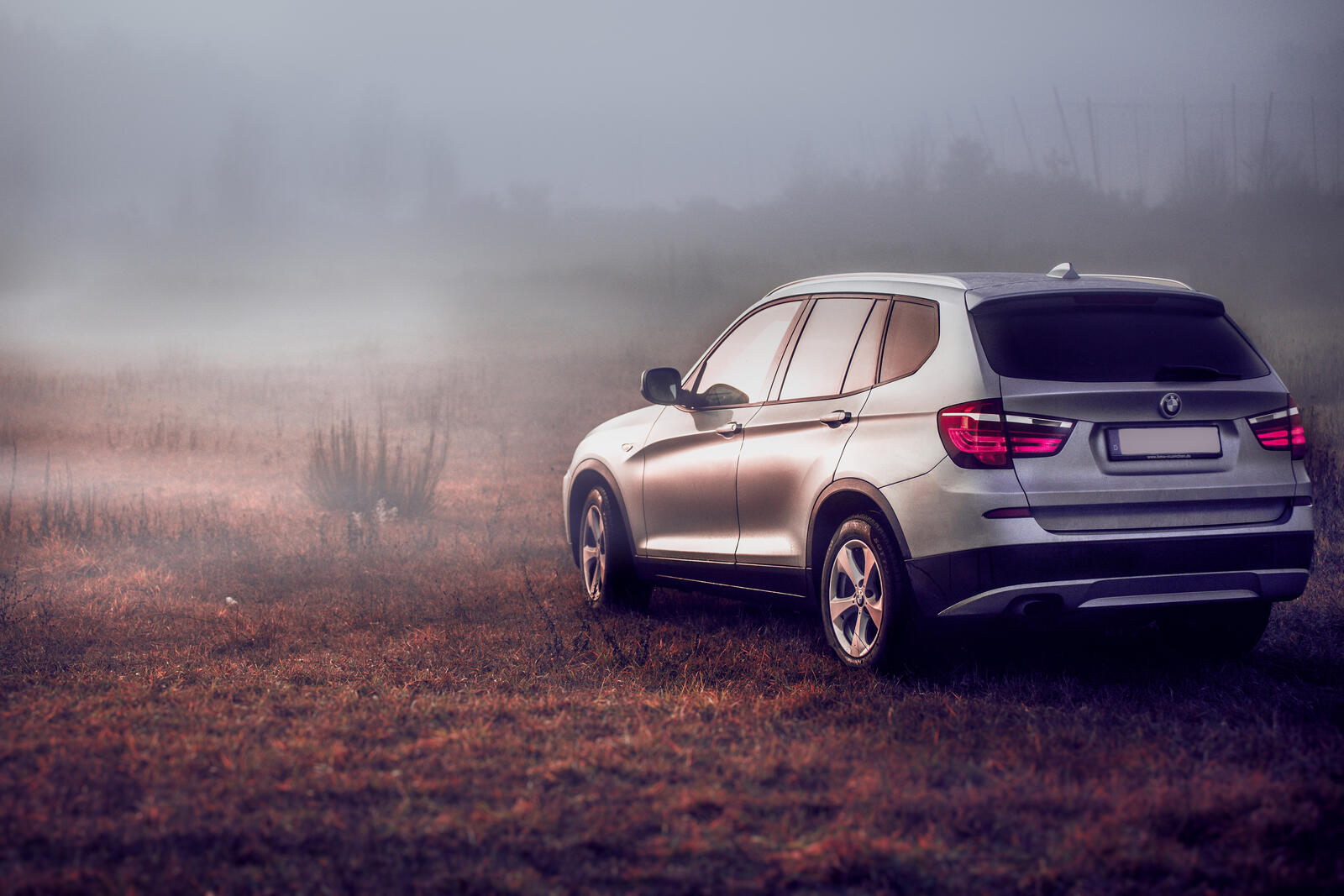 Free photo Bmw x3 in a field with fog.