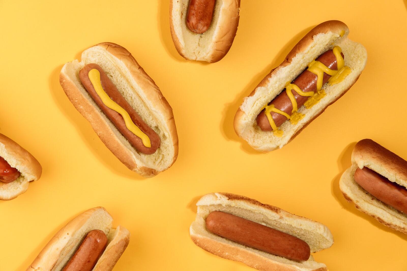 Free photo Wallpaper with hot dogs on a yellow background