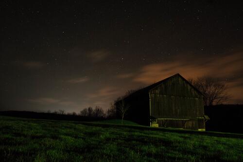 Деревянный сарай на ночном поле