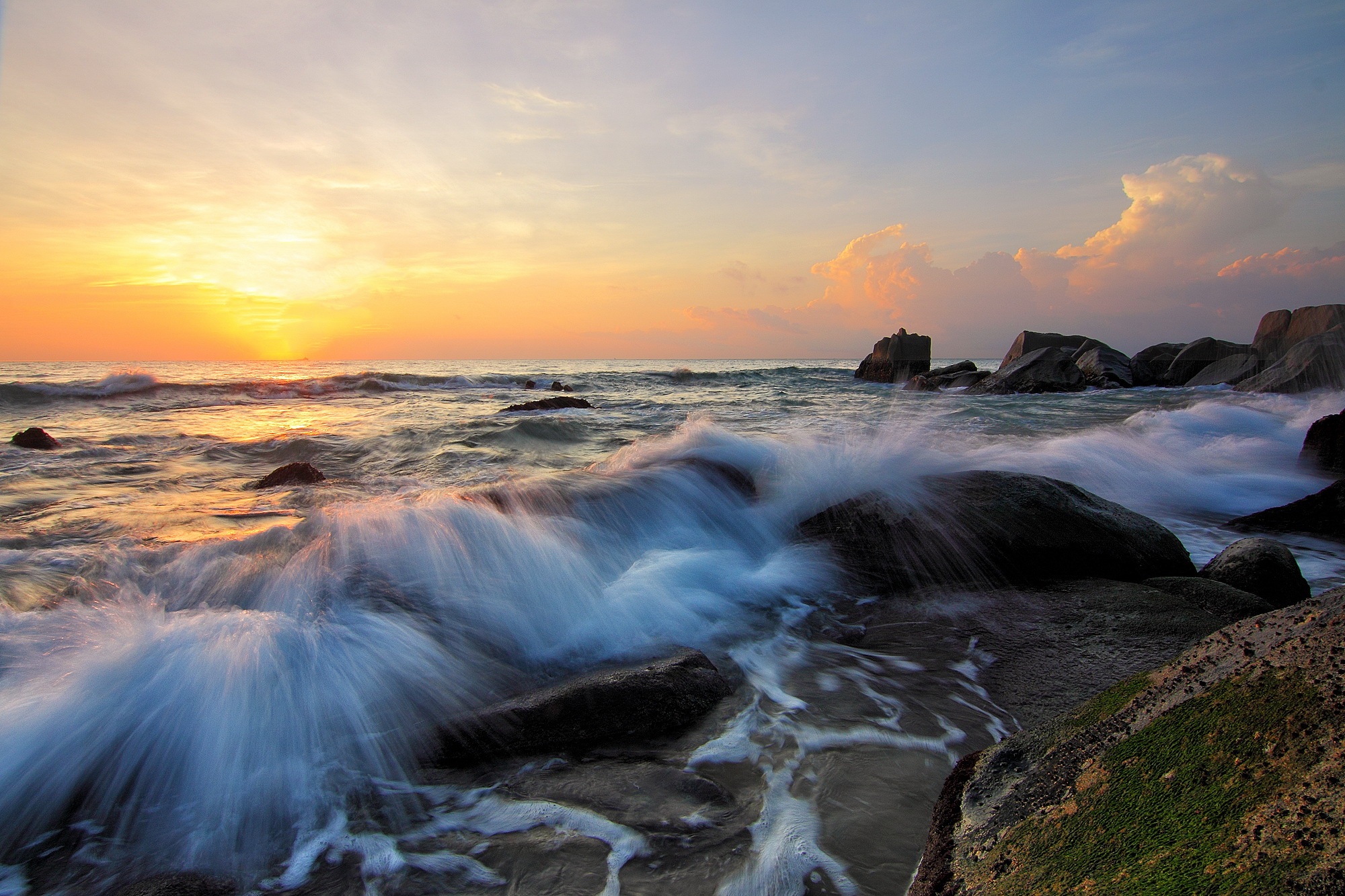 Sunset on a rocky coastline with waves
