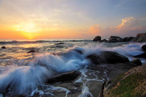 Закат на скалистом побережье с волнами