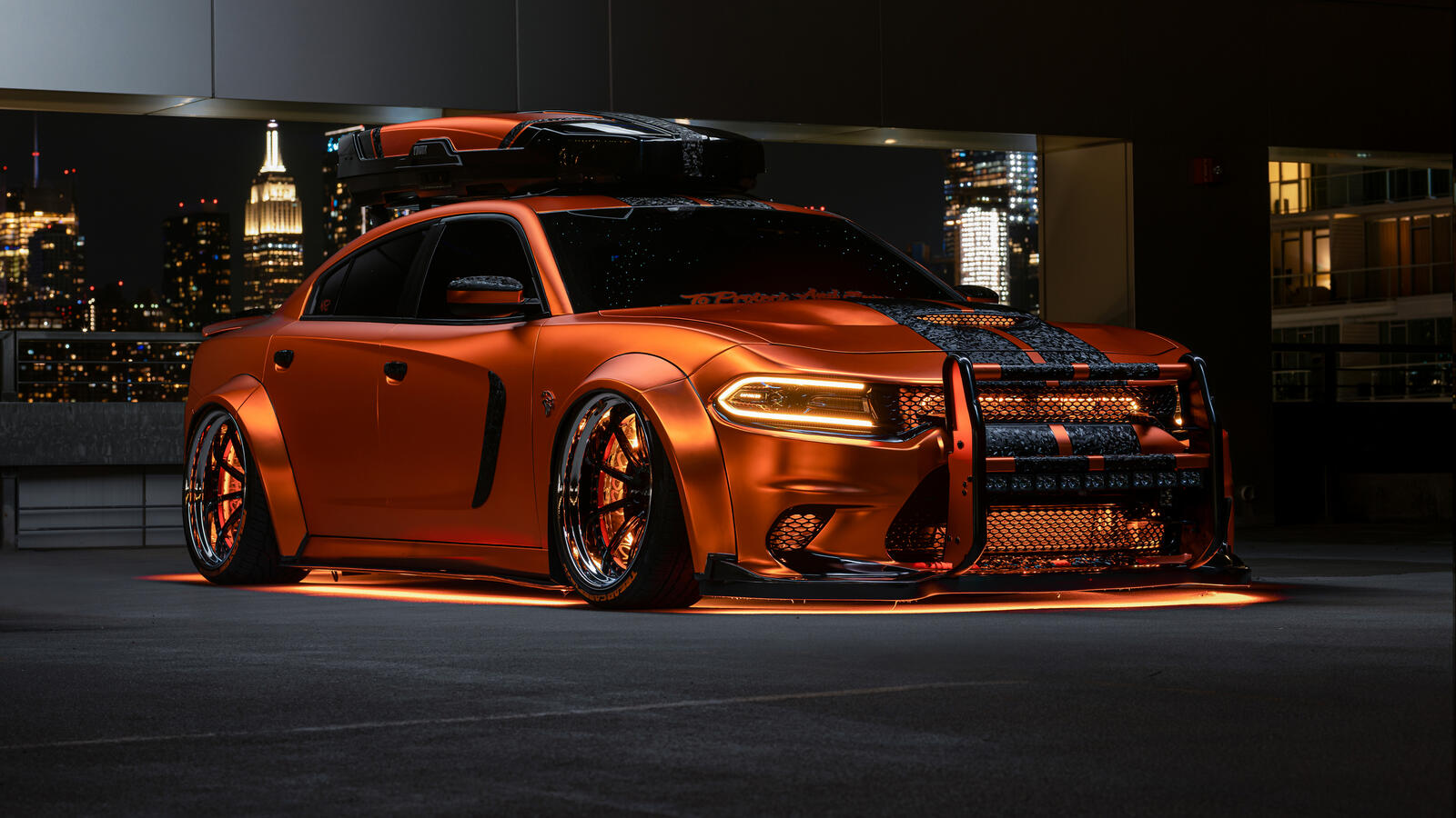 Бесплатное фото Тюнингованный Dodge Charger с оранжевыми неоновыми огнями