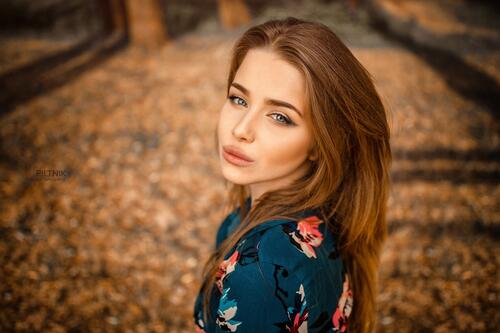 Рыжеволосая девушка делает селфи на природе осенью