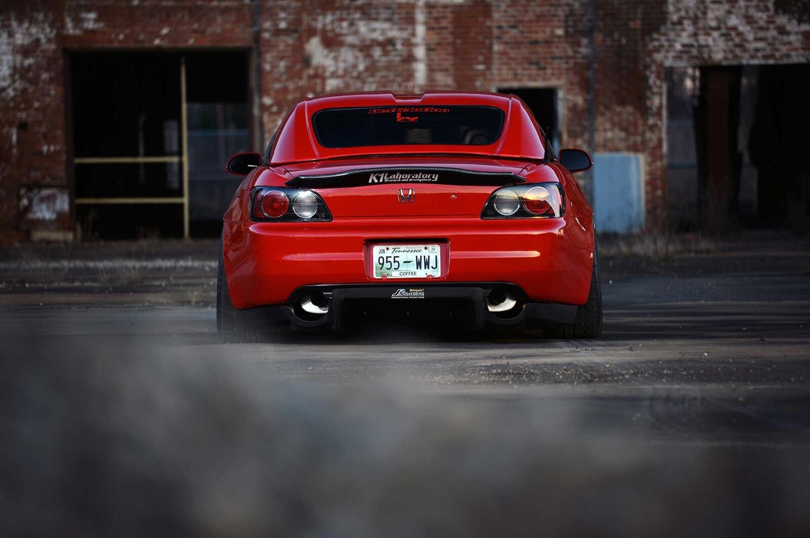 Free photo A red Honda S2000 with a dual exhaust.