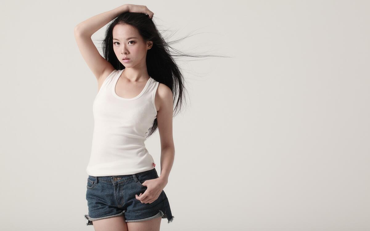 A girl in a white T-shirt and short shorts.