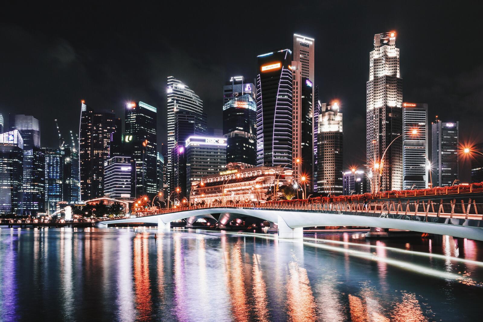 Бесплатное фото Ночной город с небоскребами отражается в реке