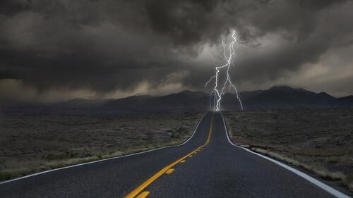 A thunderstorm on a long road outside of town