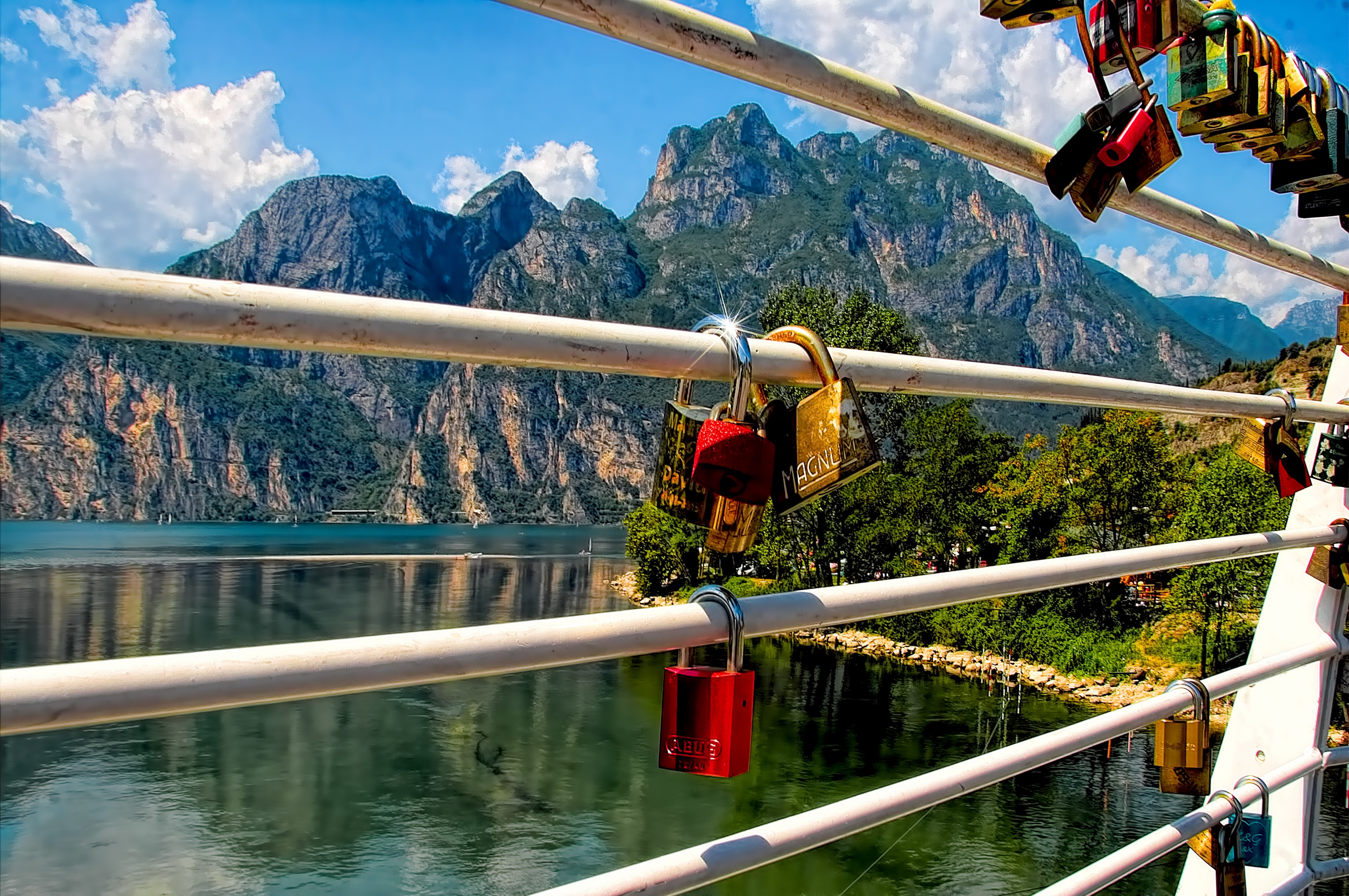 Любви замок на заборе с видом на большое озеро у гор