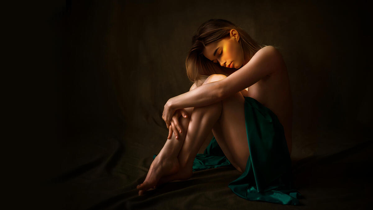 Young girl in a dark room in the sunlight