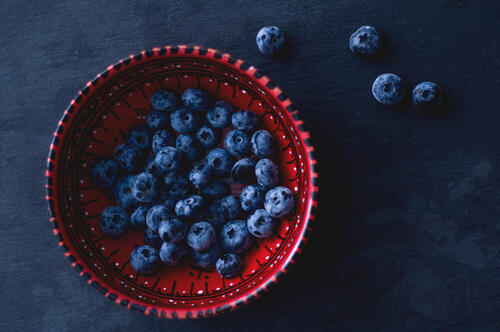 Blueberries in a red saucer