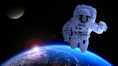 An astronaut in outer space flies at the viewer