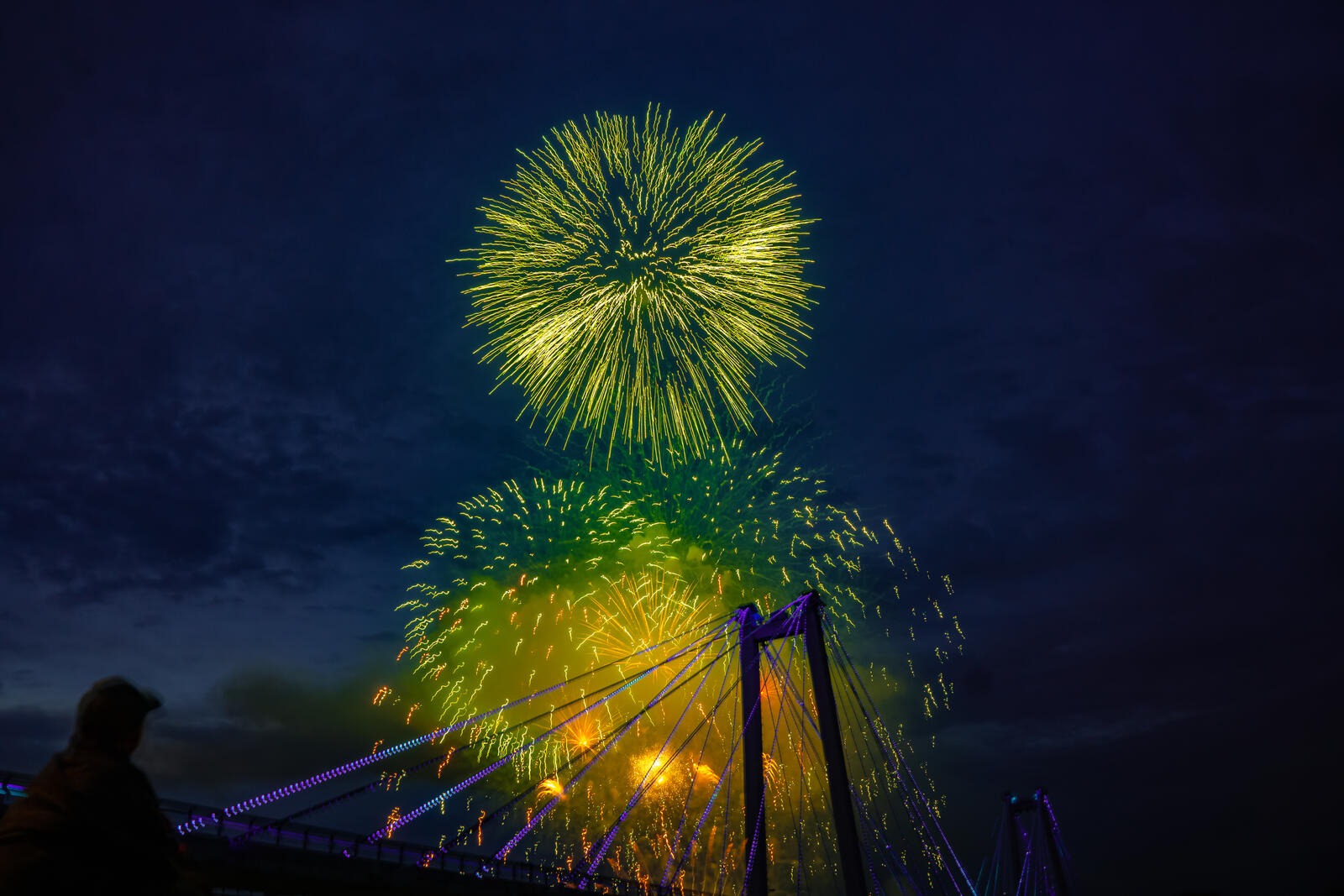Free photo Green fireworks in the night sky over the bridge