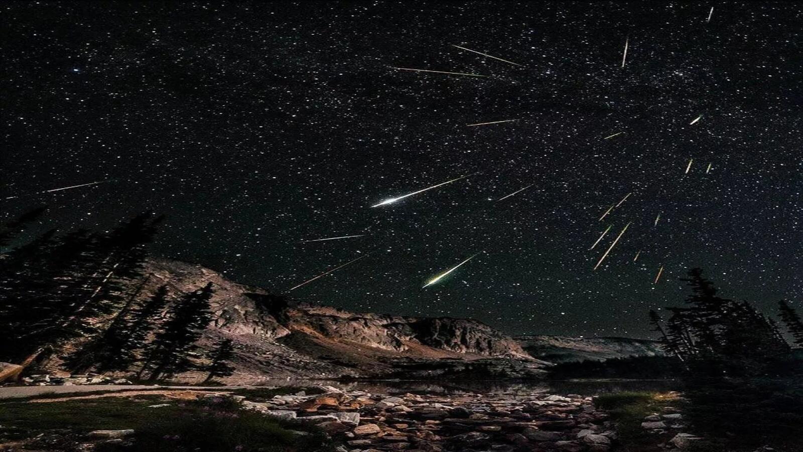 Free photo Shooting stars over mountain peaks
