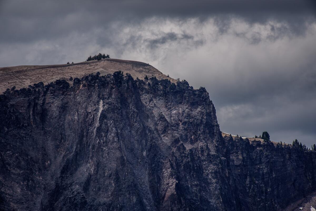 The precipice of a large cliff on a cloudy afternoon