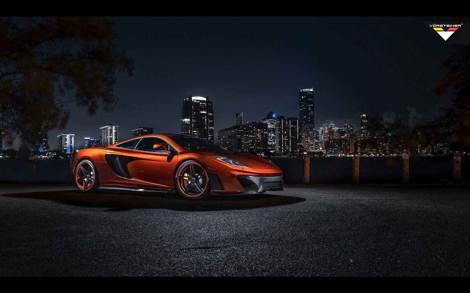 Free photo The McLaren MP4 12C against the backdrop of the city at night.
