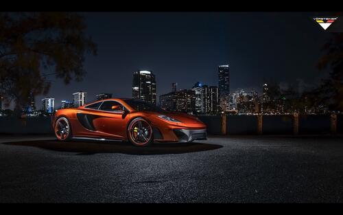 The McLaren MP4 12C against the backdrop of the city at night.