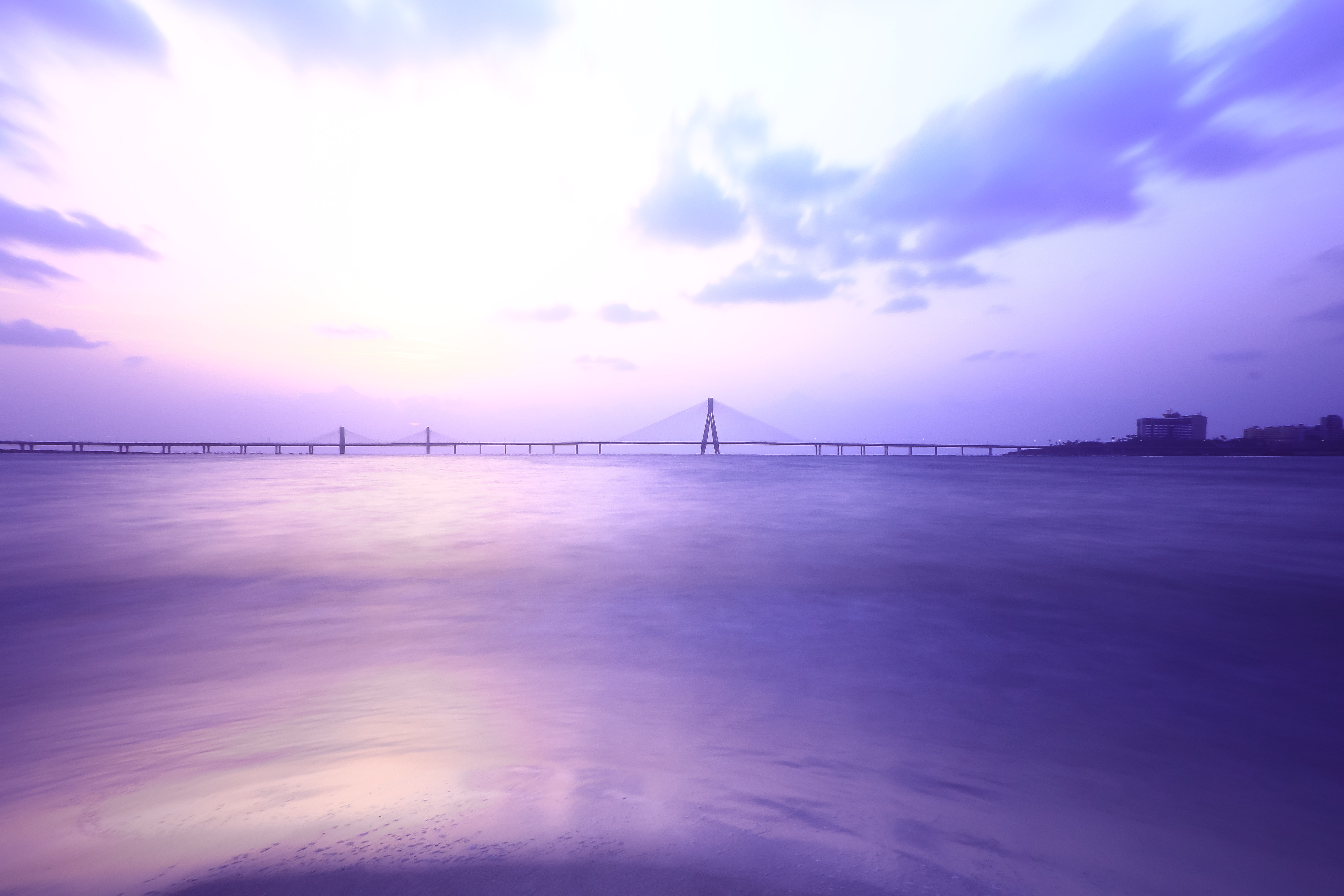 Free photo Sunrise over the bridge over the strait of the sea