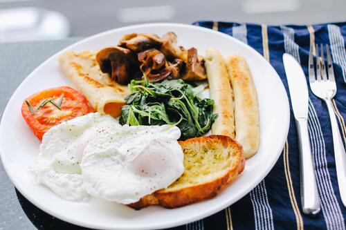 Вкусный завтрак на тарелке с мясом и яйцами