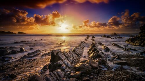 Морской закат со скалами на берегу моря