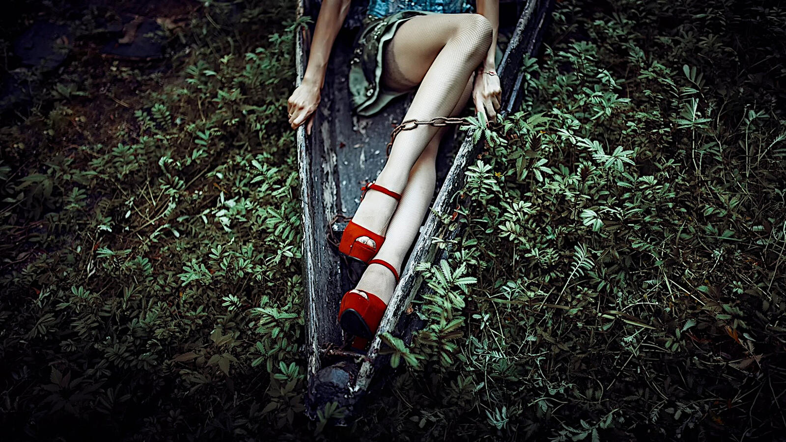 Free photo A girl in red heels in the woods.