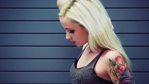 Светловолосая девушка с татуировкой на руке