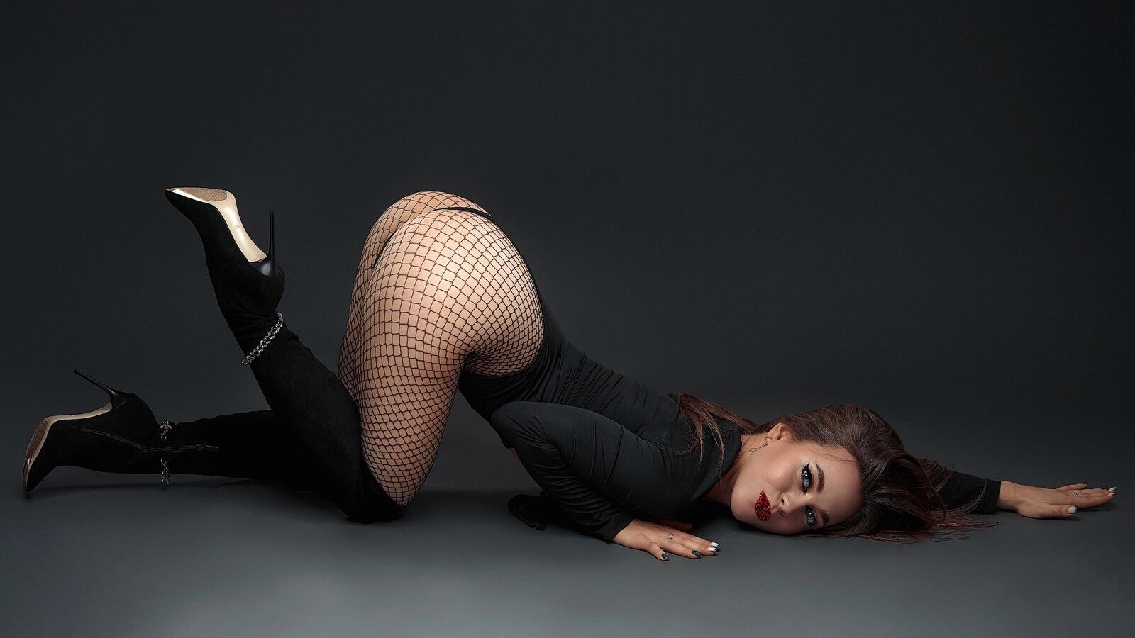 Free photo A girl in lingerie and boots lying on the floor