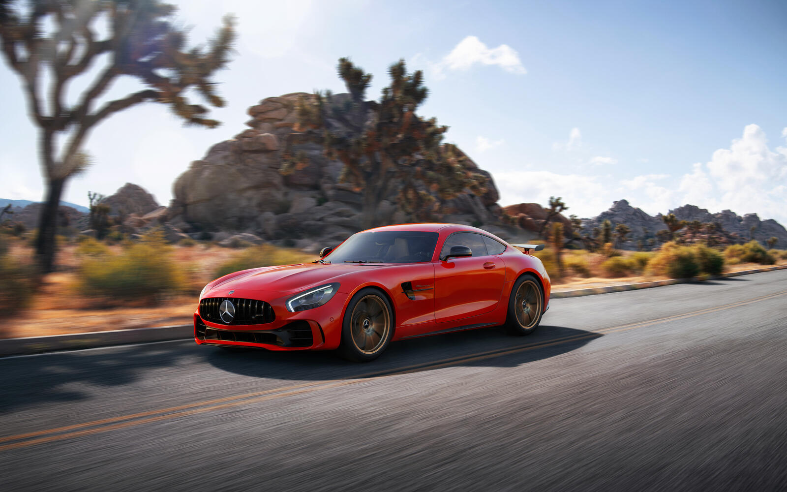 Free photo Red Mercedes AMG GTR on gold rims in motion