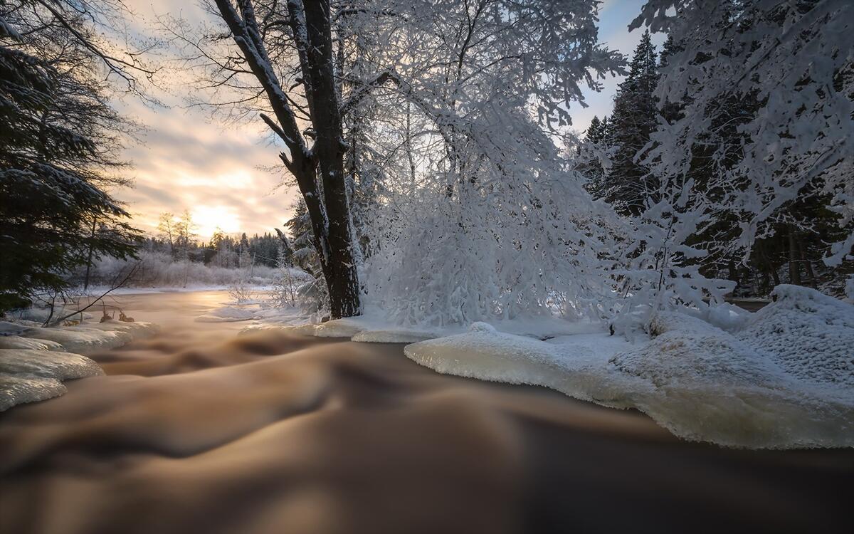 A flowing river with snow banks