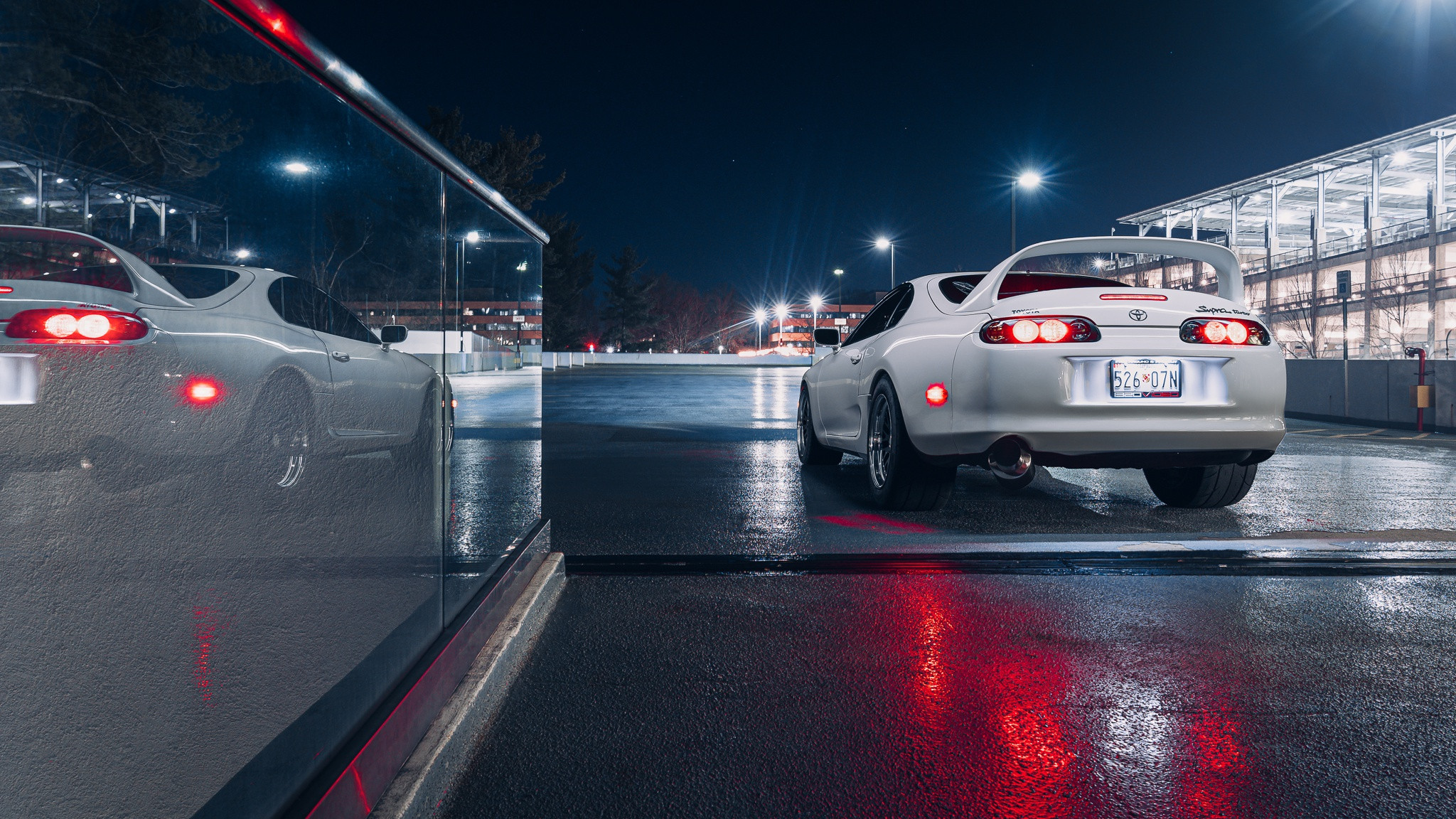 Бесплатное фото Белая Toyota Supra у торгового центра ночью