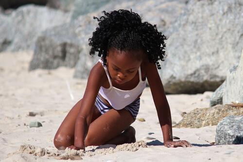 Чернокожая девочка играет с песком в Южной Африке