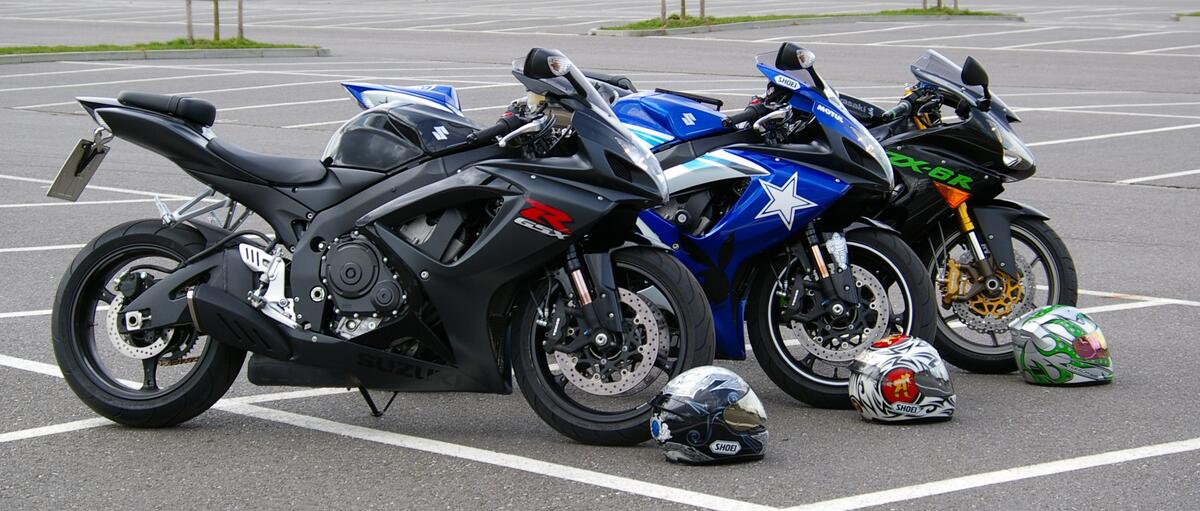 Three Kawasaki motorcycles in a parking lot.