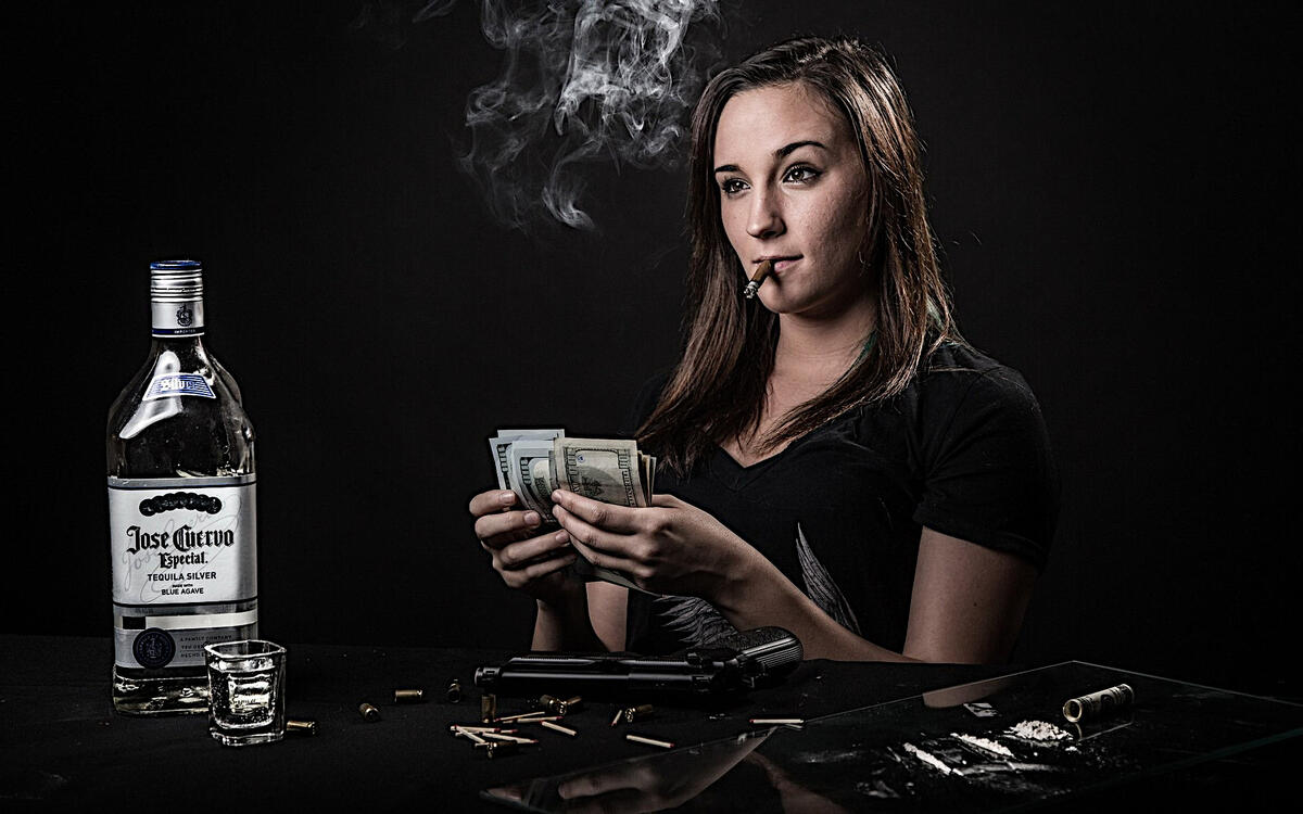 The girl with the cigar in her mouth counts dollars.