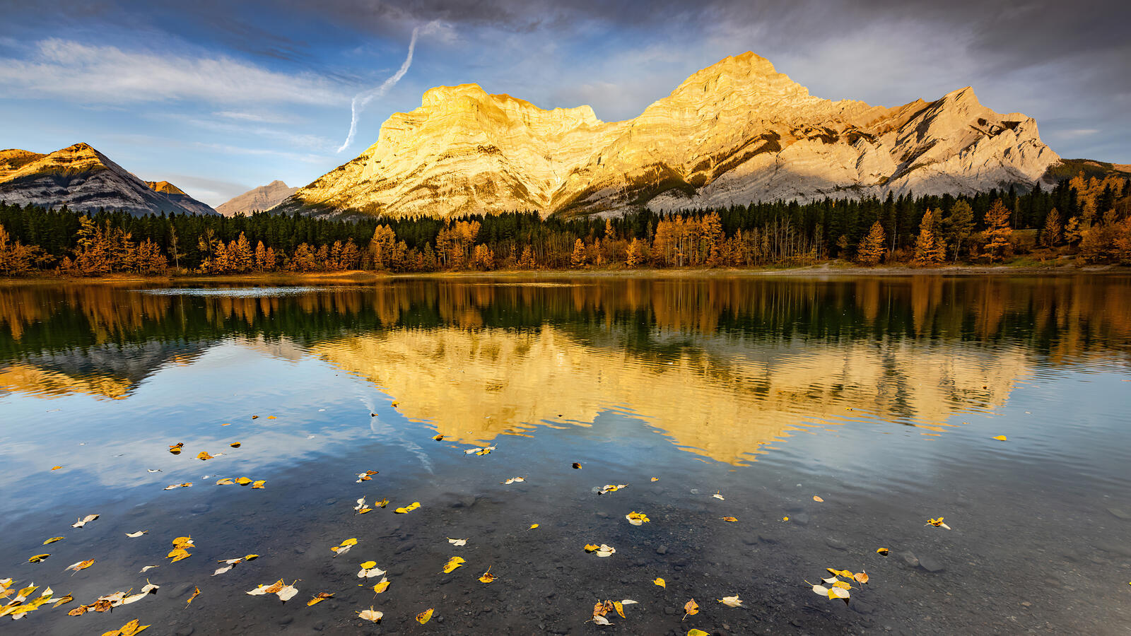 Бесплатное фото Горы освещенные солнцем отражаются в озере