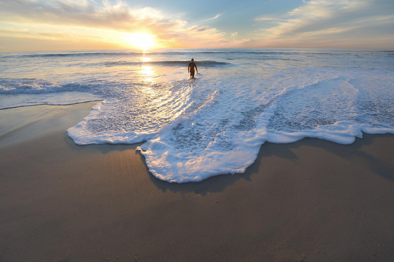 Бесплатное фото Серфер на пляже заходит в воду