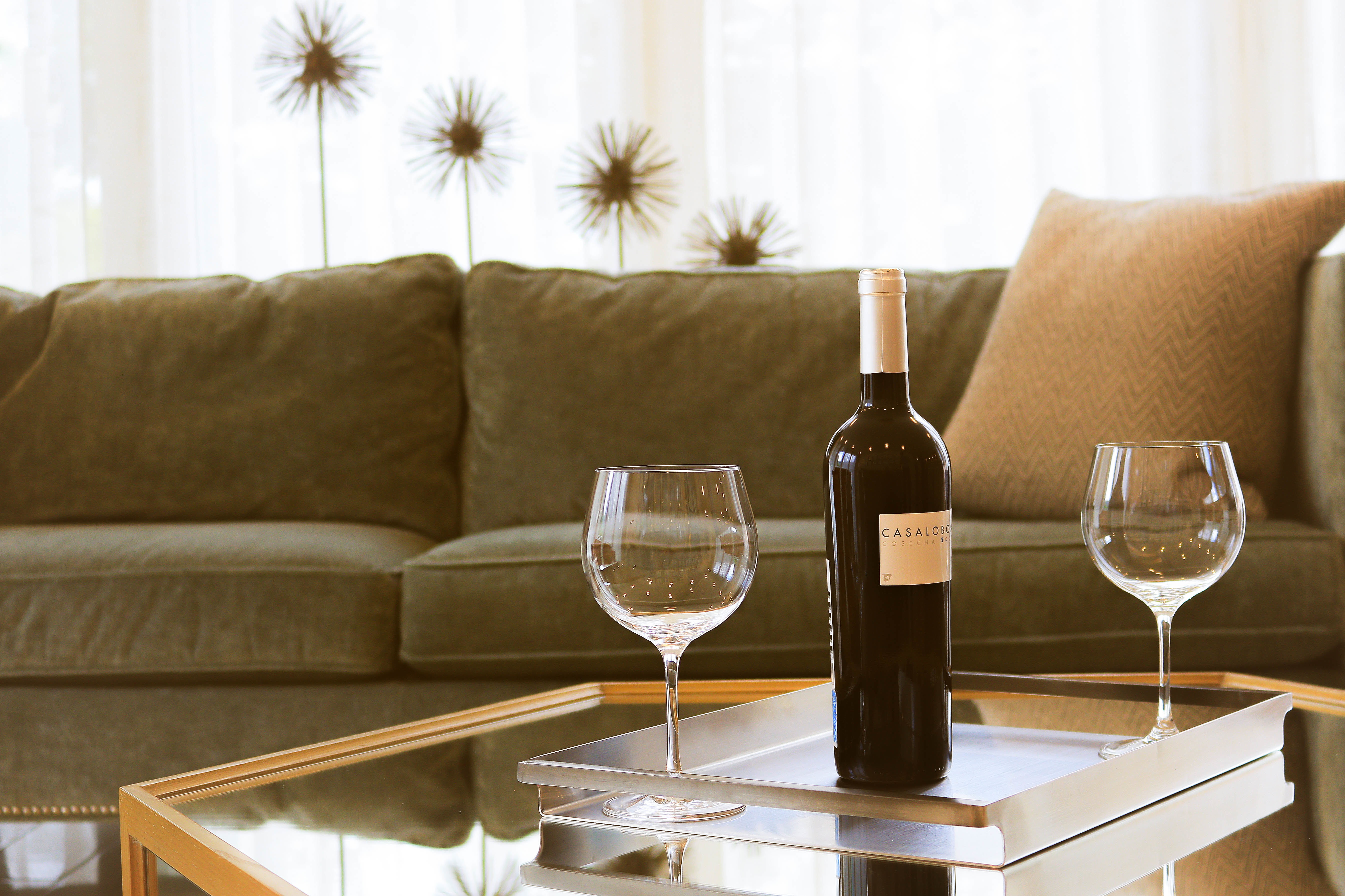 Бесплатное фото Бутылка вина с двумя бокалами стоят на журнальном столике