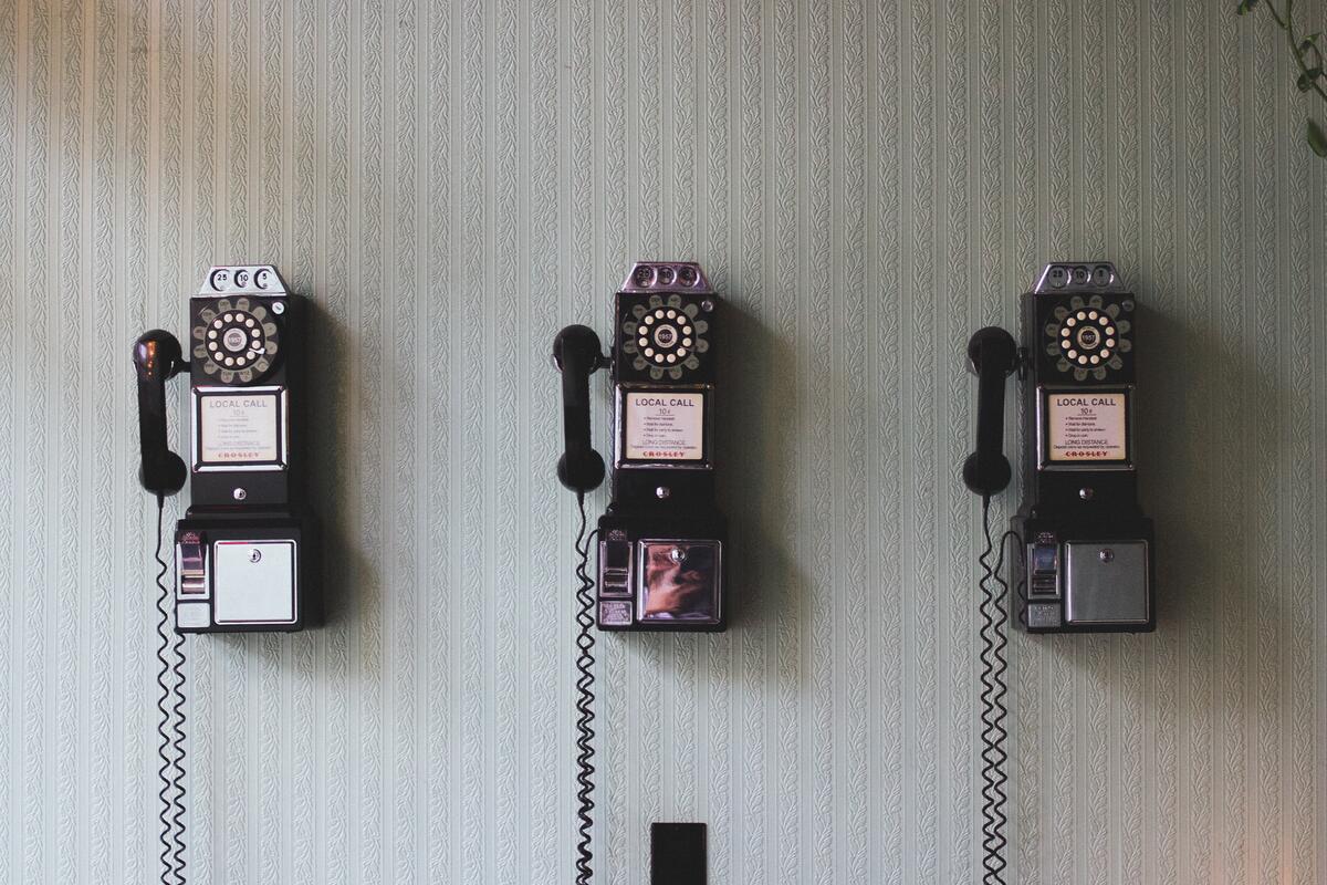 Три винтажных старинных телефона на стене