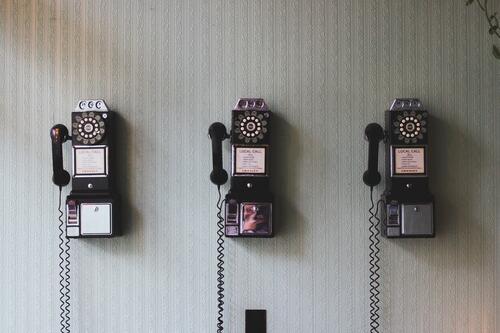 Three vintage vintage phones on the wall