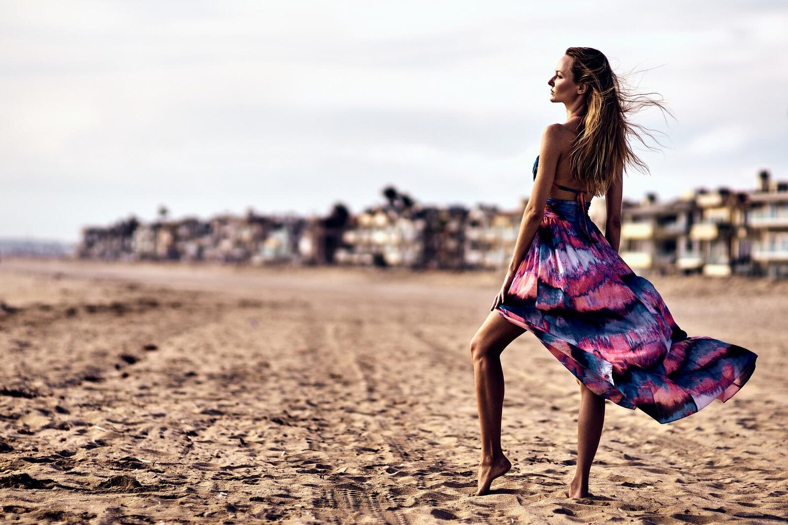免费照片女孩在有风的海滩上摆姿势