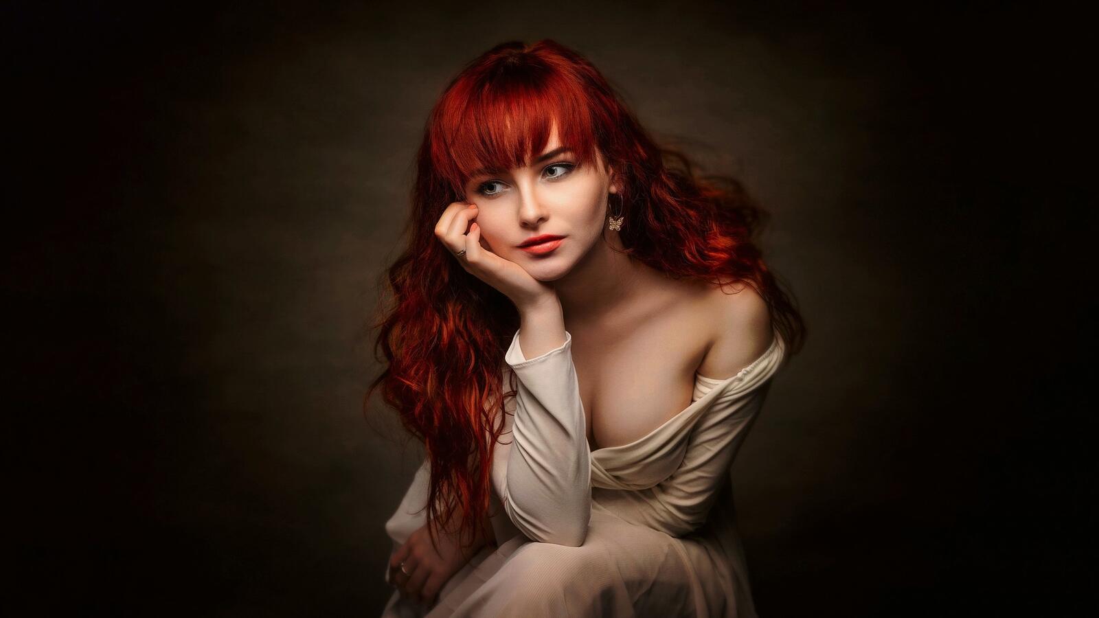 Бесплатное фото Портрет рыжей сидящей девушки