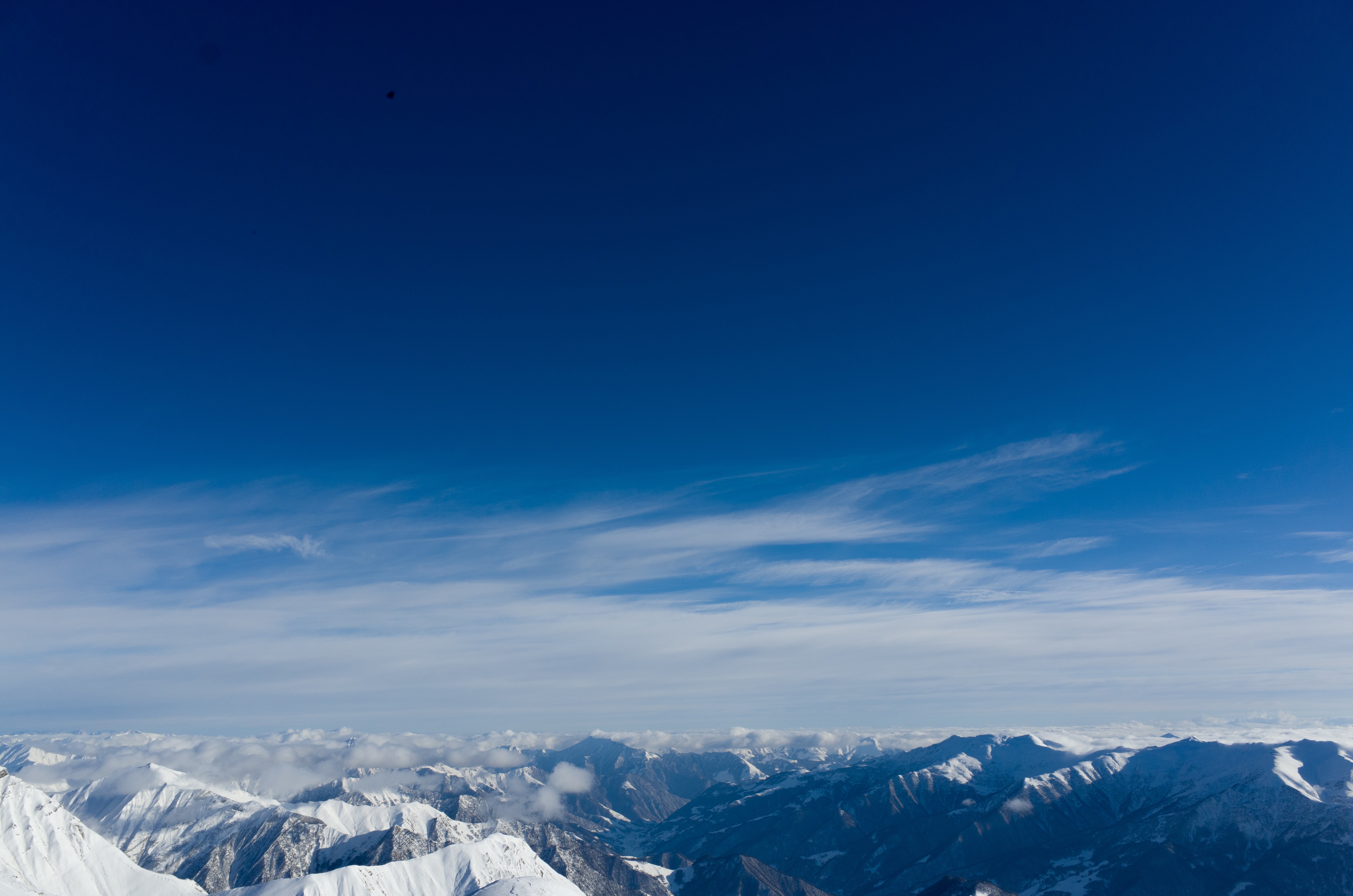 Mountainous winter terrain against the blue sky