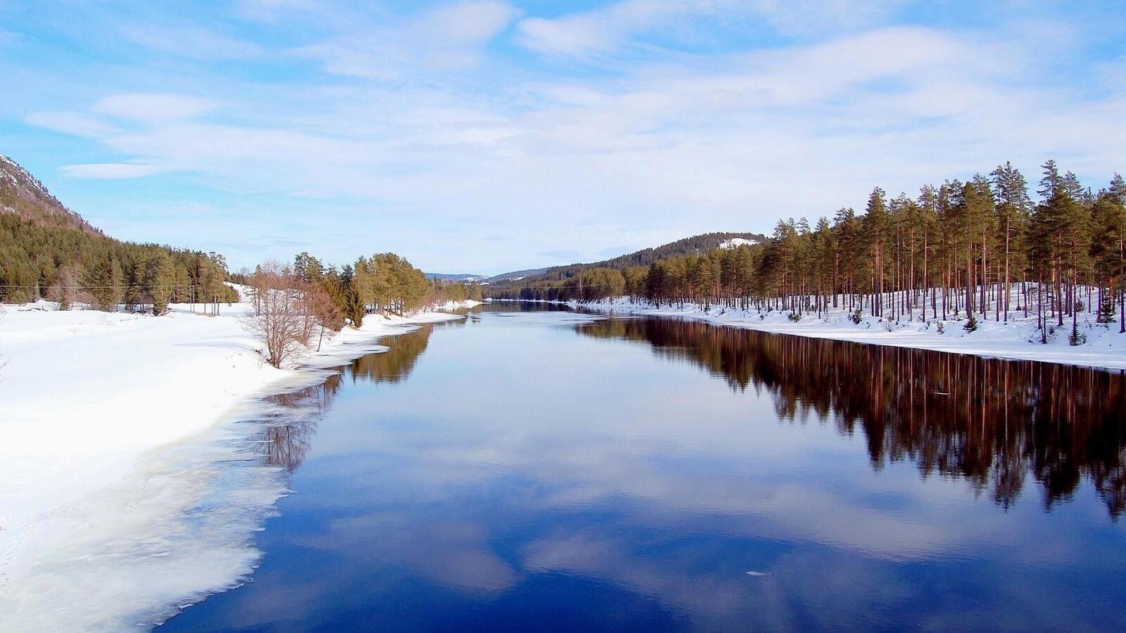 Бесплатное фото Зимняя незамерзшая река, а берега в сугробах