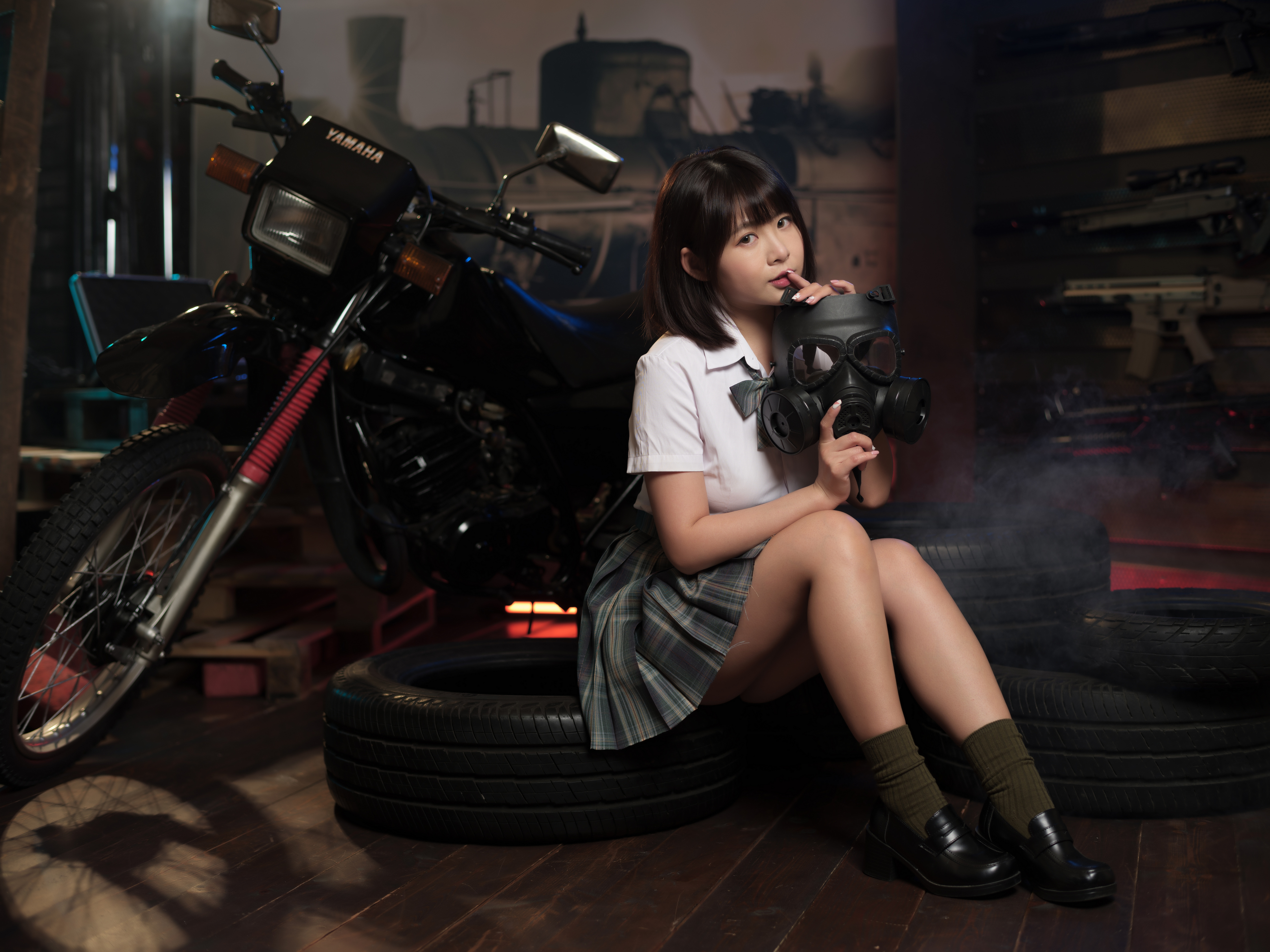 Девочка азиатской внешности на фоне кроссового мотоцикла
