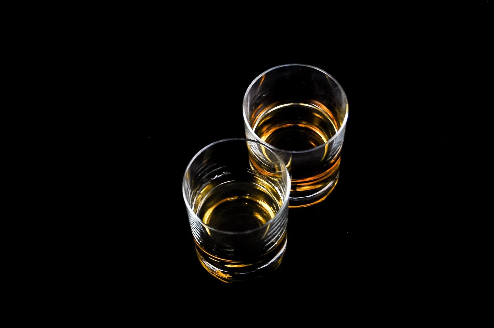 Free photo Two glasses of whiskey on a black background