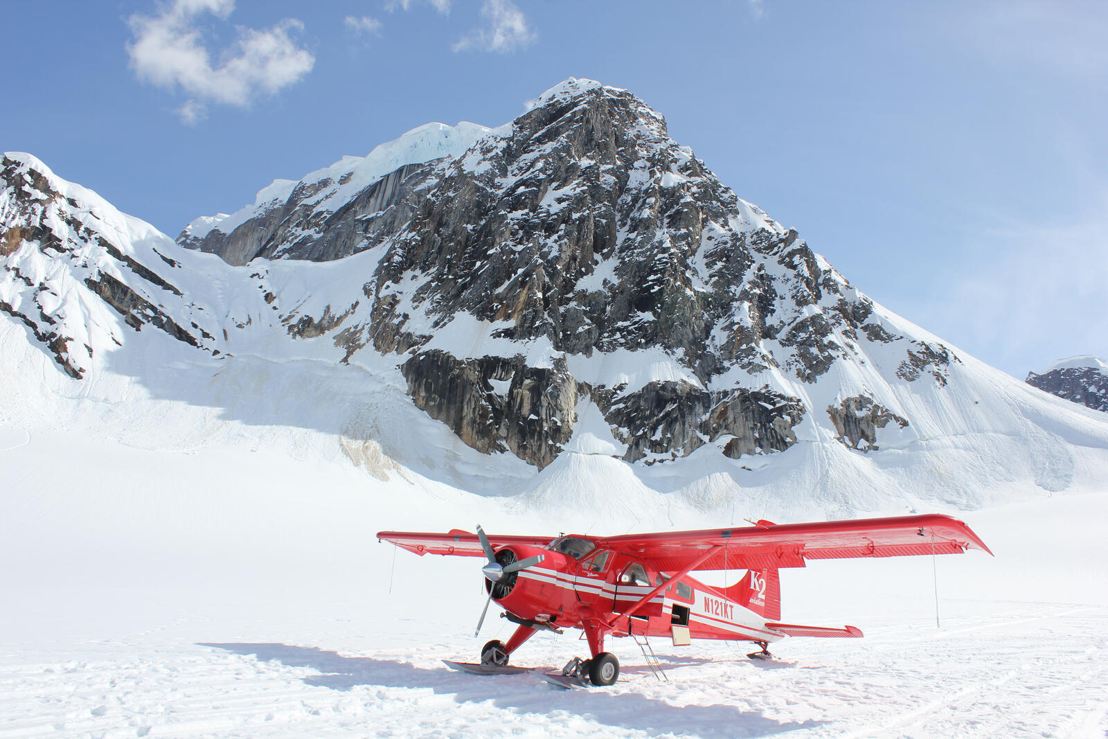 Free photo A red cornplane stands in the snowy mountains