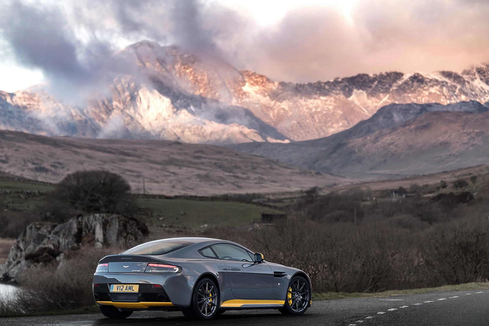Free photo Gray Aston Martin V12 Vantage S with mountains in the background