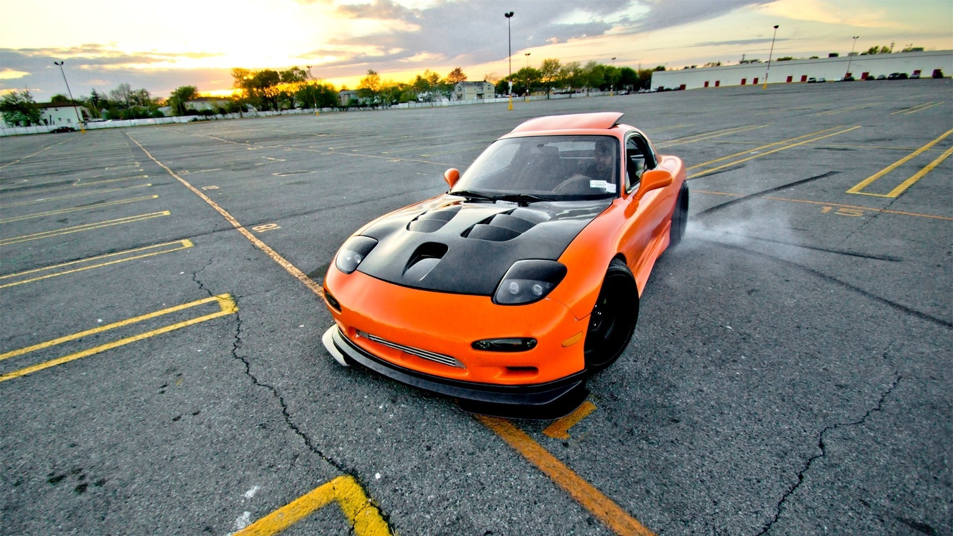Free photo An orange Mazda RX7 on a drift pad.