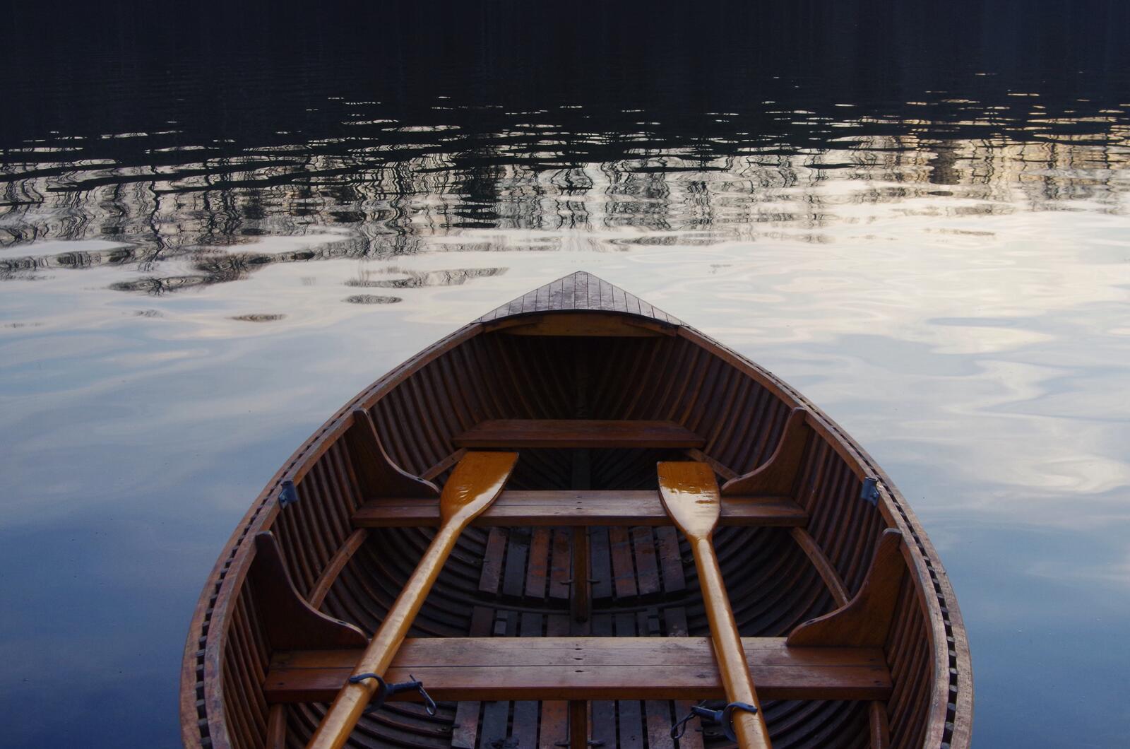 Free photo Wooden boat with oars on the river