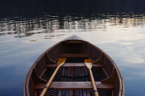 Wooden boat with oars on the river